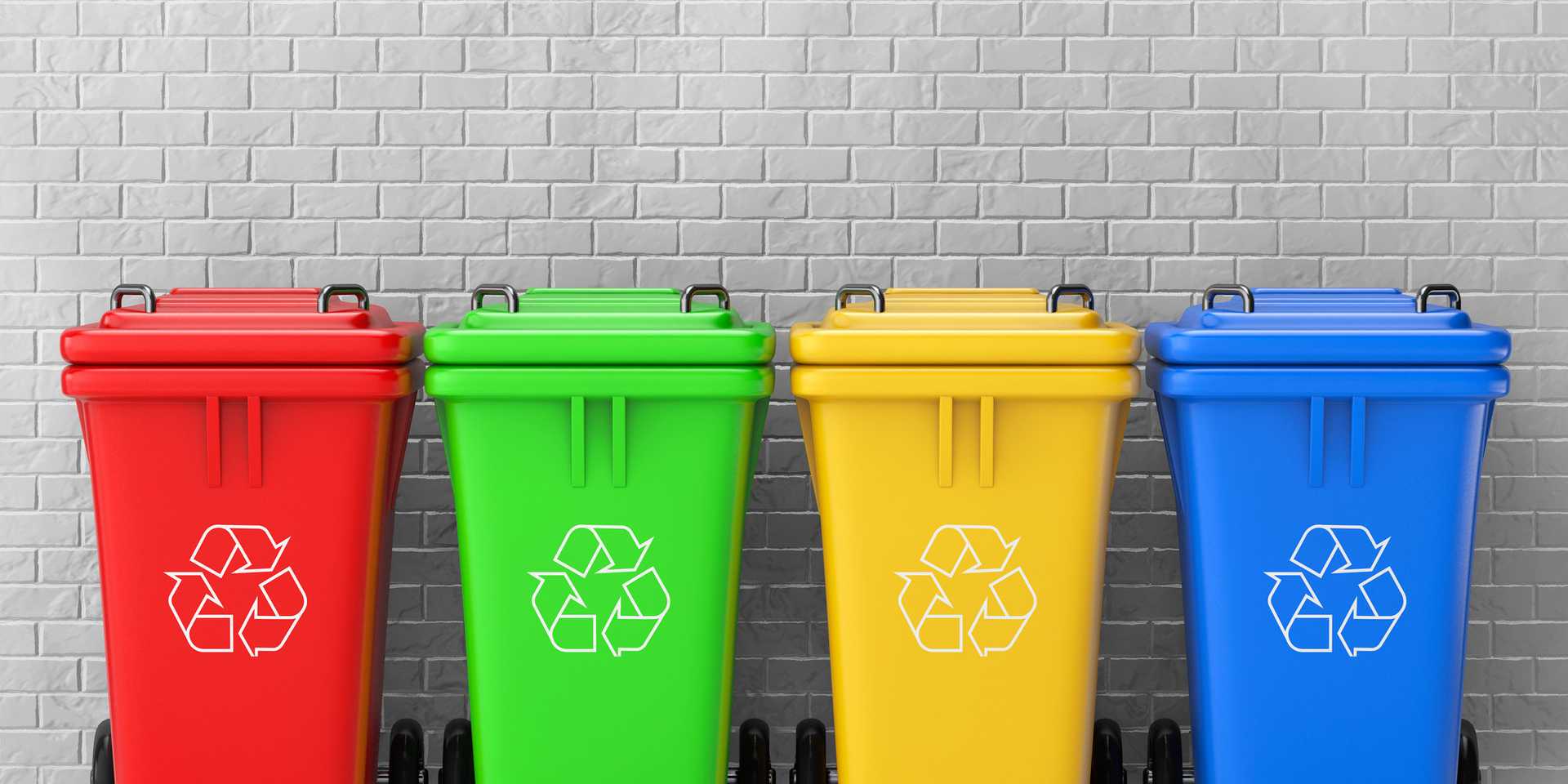 A line of red, green, yellow and blue recycling bins