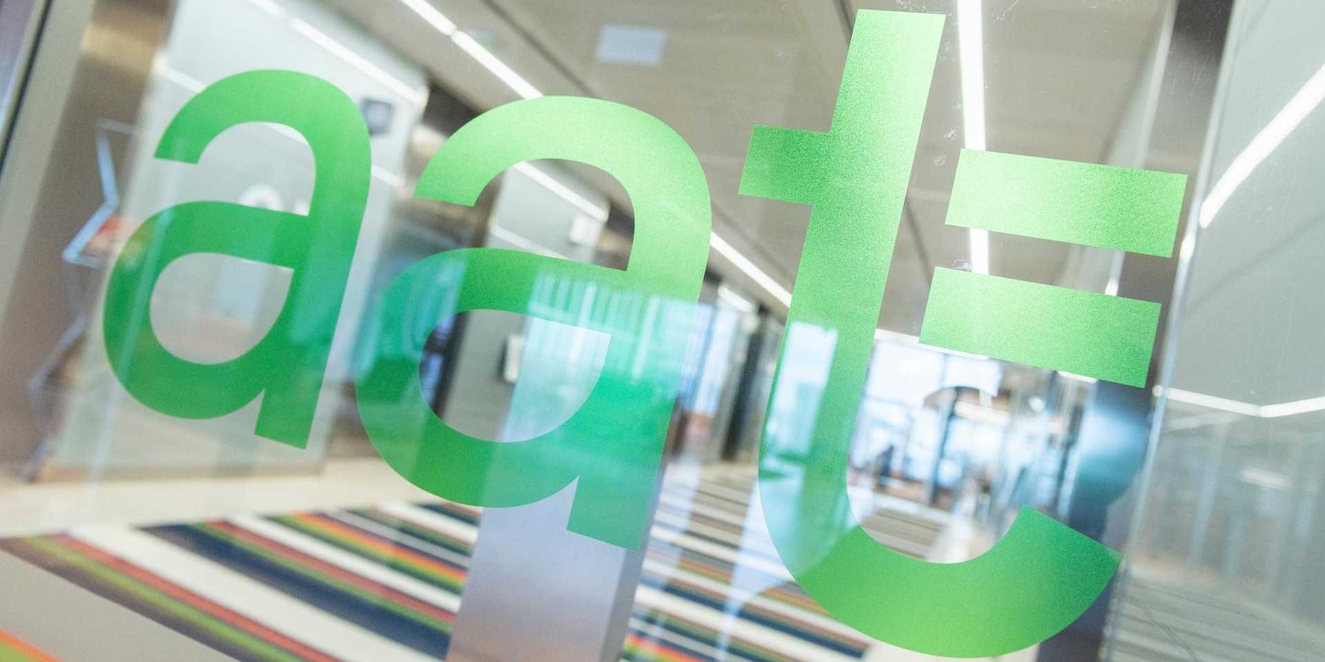 The green AAT logo on a glass window in the office