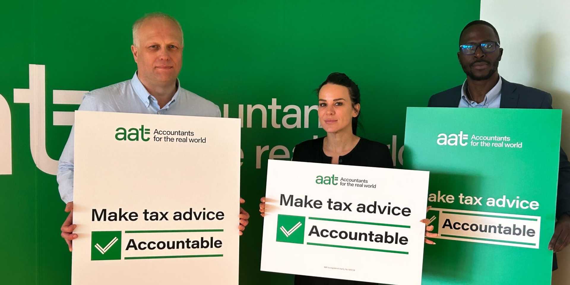 Three people holding up "Make Tax Advice Accountable" sign in front of a green wall with the AAT logo.