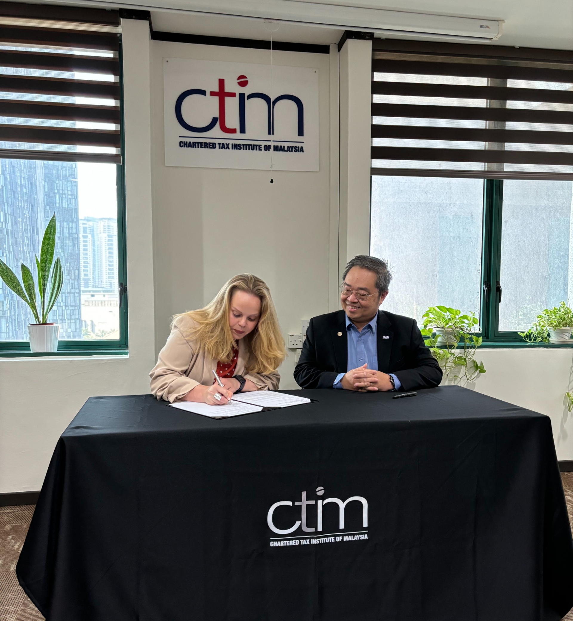 Sarah Beale signing CTIM agreement with Soh Lian Seng